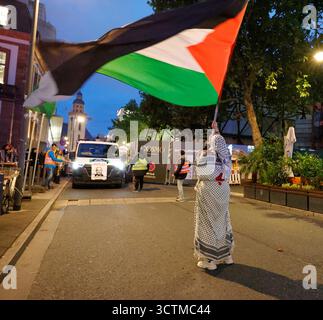 Pro-Palästina-Demo 07.10..2025 am Abend findet am zweiten Jahrestag des Hamas-Überfalls auf Israel ein Pro-Palästina-Demonstrationszug in schwarzer Kleidung mit roten Rosen mit dem Titel 77 Jahre Widerstand kein Frieden ohne Freiheit ab der Hauptwache statt. Diesen hatte das Frankfurter Ordnungsamt verboten, aber das Frankfurter Verwaltungsgericht aufgehoben hier einzelne Fahnenträgerin Frankfurt Main Hessen Deutschland *** manifestazione pro Palestina 07 10 2025 la sera, in occasione del secondo anniversario dell'attacco di Hamas contro Israele, una manifestazione pro Palestina in abiti neri con ros rossi Foto Stock