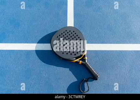 Vista ad alto angolo della racchetta da tennis del padel sulla superficie blu del campo all'aperto Foto Stock
