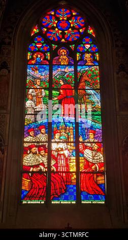 Una colorata vetrata commemorativa all'interno della Chiesa Votiva di Vienna, Austria Foto Stock