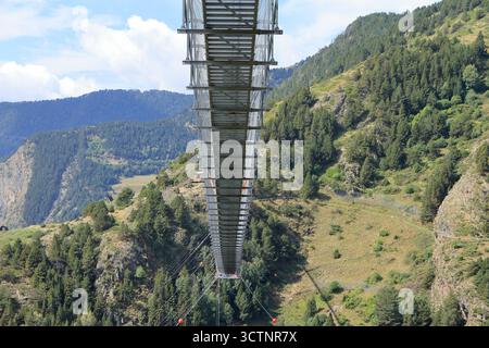 La vista ad angolo basso dei visitatori che camminano sul Ponte tibetano, un ponte sospeso in metallo di 603 m oltre 158 m di profondità nella valle di Vall del Riu, Canillo, Andorra Foto Stock