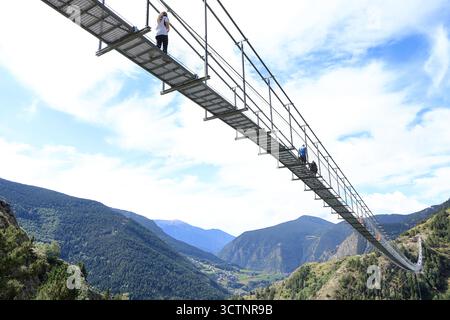 La vista ad angolo basso dei visitatori che camminano sul Ponte tibetano, un ponte sospeso in metallo di 603 m oltre 158 m di profondità nella valle di Vall del Riu, Canillo, Andorra Foto Stock