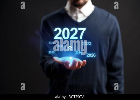 Previsione della tempistica futura visualizzata in una mano con particolare attenzione all'anno 2027 Foto Stock