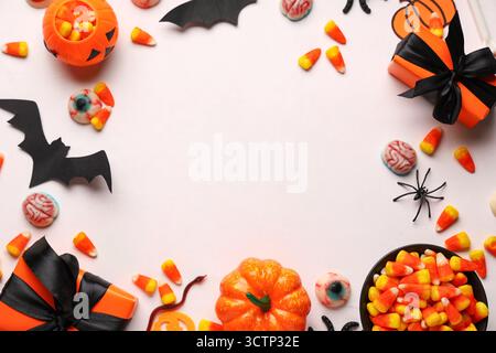 Cornice realizzata in grani dolci con scatole regalo e diverse decorazioni su sfondo bianco. Festa di Halloween Foto Stock
