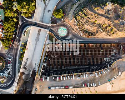 Ripresa mattutina dall'alto di un parcheggio, di una rotatoria circolare e di un drenaggio delle tempeste a San Andrés, Tenerife, per catturare il layout urbano e le infrastrutture Foto Stock