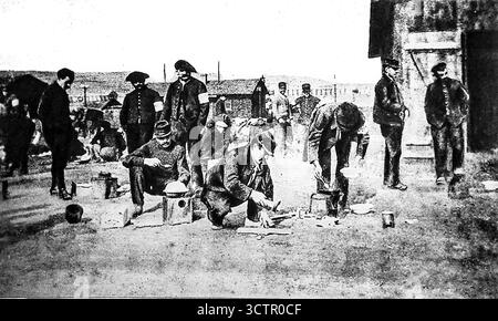 Pubblicato su le Miroir, 30 gennaio 1916. I prigionieri alleati in un campo tedesco preparano i pasti all'aperto utilizzando utensili improvvisati come vecchie scatole per biscotti. L'immagine evidenzia le strutture inadeguate e la difficile vita quotidiana sopportata dai prigionieri di guerra durante la prima guerra mondiale. Nonostante le rivendicazioni tedesche di efficienza del campo, la preparazione del cibo spesso si svolgeva in condizioni non sanitarie, esponendo i prigionieri alla fame, alle malattie e alle difficoltà. Foto Stock