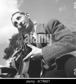 Fotografo di stampa Sven Malm a Skansen, aprile 1940, con la sua fotocamera Rolleiflex pronta. Questa fotocamera di medio formato, prodotta dalla ditta tedesca Franke & Heidecke (ora nota come Rollei), poteva catturare 12 esposizioni per rotolo su pellicola 6x6 cm. Il formato cinematografico, designato come "120" da Kodak, è diventato immensamente popolare tra i fotografi professionisti per la sua eccezionale qualità delle immagini e versatilità. Introdotta alla fine degli anni '1920, la Rolleiflex era rinomata per il suo design reflex a doppia lente, che forniva messa a fuoco e composizione precise. La sua struttura robusta e l'ottica nitida lo hanno reso un compagno affidabile Foto Stock