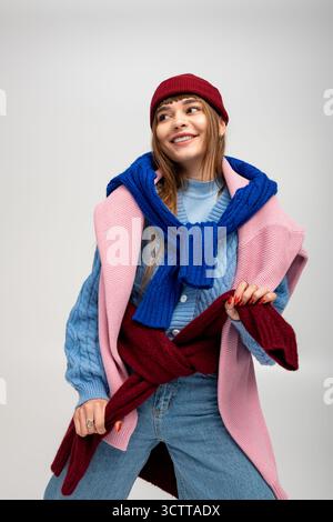 La giovane donna indossa con gioia un abbigliamento caldo ed elegante, che mostra il suo spirito allegro. Foto Stock