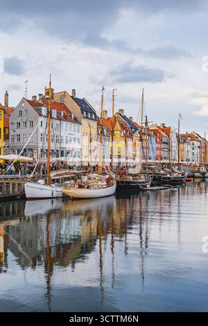 Case tradizionali colorate nel vecchio porto di Nyhavn viste con le barche che galleggiano sull'acqua nel canale. Foto di alta qualità Foto Stock