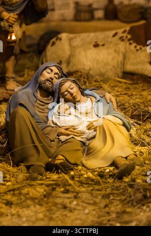 La Sacra famiglia dorme pacificamente in una mangiatoia, il bambino Gesù cullato tra le braccia di Maria, Giuseppe riposa accanto a loro. Foto Stock