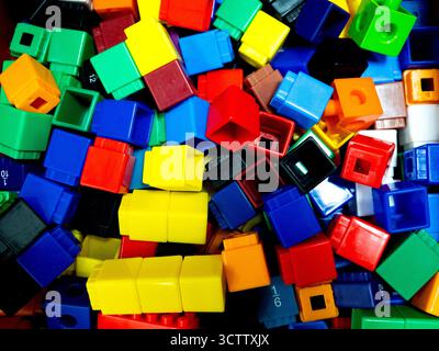 Una vivace pila di blocchi di giocattoli in plastica multicolore di varie forme e dimensioni, ideale per il gioco dei bambini e l'apprendimento precoce. Questo luminoso edificio blo Foto Stock