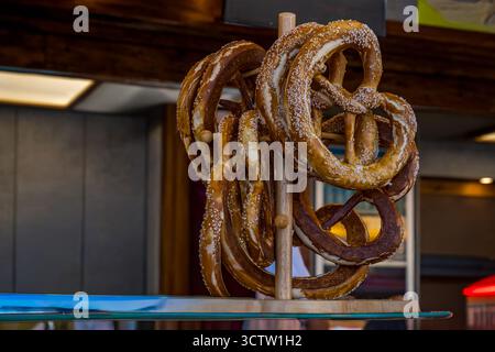 I tradizionali pretzel bavaresi esposti su una griglia di legno in una panetteria o in un mercato alimentare tedesco Foto Stock