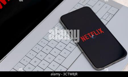 Ottawa ON, Canada - 06 ottobre 2025: Smartphone con app Netflix su tastiera per laptop, che mostra la tecnologia moderna e l'intrattenimento digitale con copia Foto Stock