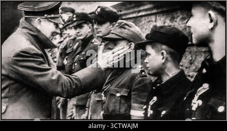 HITLER BERLINO GLI ULTIMI GIORNI HA ASSEGNATO MEDAGLIE AI GIOVANI HITLER 1945 una delle ultime apparizioni pubbliche e immagini dell'incontro di Adolf Hitler che ringraziava e assegnava medaglie ai suoi ferocemente leali e coraggiosi membri della Hitlerjugend della Gioventù Hitlerjugend. Aprile 1945 Battaglia per Berlino seconda guerra mondiale Foto Stock