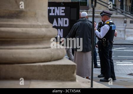 Londra, Regno Unito. 7 ottobre 2025. Gli agenti della polizia metropolitana informano gli attivisti pro-palestinesi che cominciano a riunirsi fuori dalla Broadcasting House della BBC per una protesta che la polizia metropolitana ritiene sia stata organizzata da un gruppo noto come Intifada 87 che le condizioni del Public Order Act che proibivano l'assemblea fuori dalla Broadcasting House erano state imposte alla protesta poco prima. Le condizioni vietavano l'ingresso dei manifestanti in una zona intorno a Broadcasting House delimitata da Marylebone Road, Great Titchfield Street, Great Castle Street e Harley Street e gli attivisti erano quasi immediatamente Foto Stock