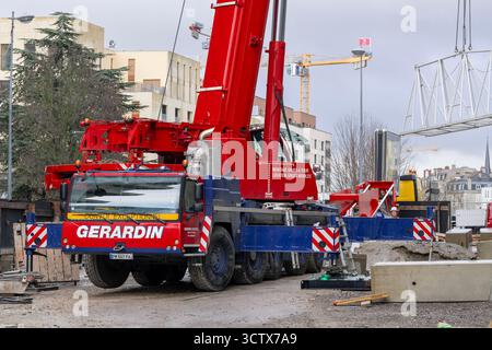 Nancy, Francia - Vista su una gru mobile rossa Liebherr LTM 1230-5.1 per lo smontaggio di una gru a torre Potain in un cantiere. Foto Stock