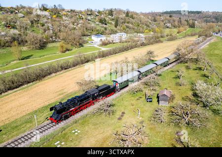 Weissach, Germania - 7 aprile 2025: Treno a vapore Feuriger Elias sulla ferrovia di Strohgäubahn foto aerea dall'alto a Weissach, Germania. Foto Stock