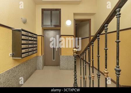 Ingresso classico con pavimento in marmo, scala a chiocciola in metallo e affreschi decorativi sul soffitto a volta Foto Stock