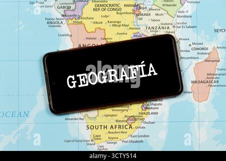 Primo piano di uno smartphone con la parola geografica in spagnolo sul sud dell'africa mappa politica Foto Stock