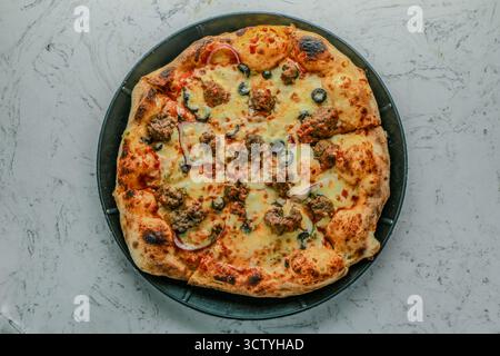 Polpette italiane bollite e condite con salsa Marinara, mozzarella, condite con cipolle, peperoni e olive. Foto Stock