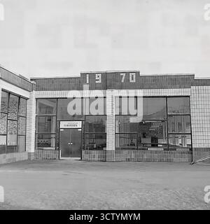 L'ingresso centrale di un nuovo mercato coperto a Sloviansk, la RSS Ucraina, è catturato in questa foto architettonica esplicitamente datata 1970 sulla sua facciata. Questo edificio e' un ottimo esempio di design modernista sovietico, caratterizzato da un esterno piastrellato, grandi finestre di vetro e un cartello 'Dobro Pozhalovat' (benvenuto) sulla porta. L'importante esposizione dell'anno segna il suo completamento durante il centenario della nascita di Lenin, rendendolo un artefatto significativo dello sviluppo urbano dell'era Brezhnev Foto Stock