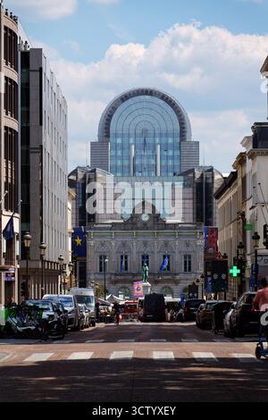 Persone e automobili di fronte all'edificio del Parlamento europeo viste attraverso strade trafficate il 20 maggio 2025 a Bruxelles, Belgio. Foto Stock