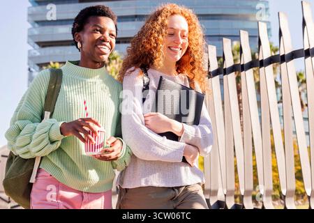 due giovani studenti che camminano lungo la strada Foto Stock