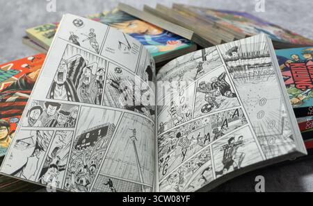 South Kalimantan, Indonesia - 12 08 2023 : Una pila di fumetti o manga giapponesi con il titolo Giant Killing con una pagina aperta su sfondo grigio con Foto Stock