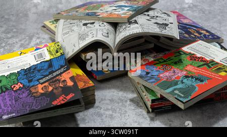 South Kalimantan, Indonesia - 12 08 2023 : Una pila di fumetti o manga giapponesi con il titolo Giant Killing con una pagina aperta su sfondo grigio con Foto Stock