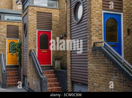 Moderne case cittadine in mattoni con porte anteriori colorate a Londra, Regno Unito. Foto Stock