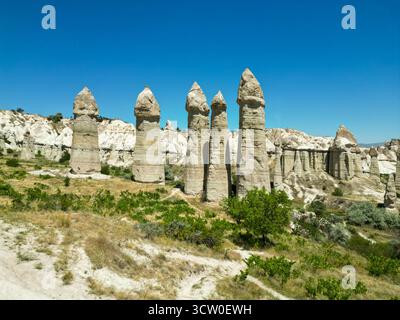 Una splendida vista ad alto angolo delle famose formazioni rocciose del camino delle fate nella Valle dell'amore (Bağlıdere Vadisi), vicino a Göreme in Cappadocia, Turchia. Foto Stock