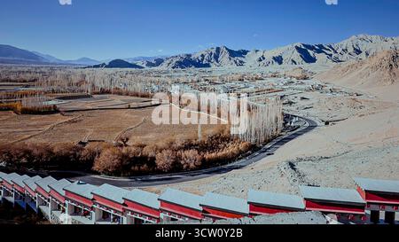 Vista panoramica della valle di Leh Ladakh con strada tortuosa, terreni agricoli e città adagiati sulle aride montagne dell'Himalaya, India Foto Stock