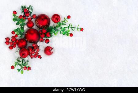 Decorazione natalizia. Palla di Natale rossa, albero di Natale rami, bacche rosse e mele sulla neve con spazio per testo. Vista dall'alto, disposizione piatta Foto Stock