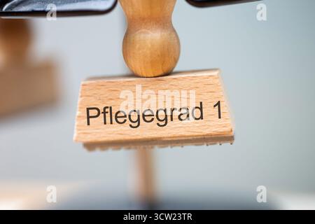 (Montaggio fotografico) primo piano di un francobollo con l'iscrizione PFLEGEGRAD 1 Foto Stock