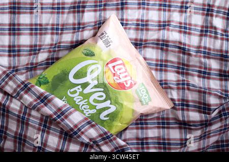 KIEV, UCRAINA - 19 APRILE 2025 giace lo yogurt al forno con patatine aromatizzate all'erba in una confezione verde con il logo ufficiale Foto Stock