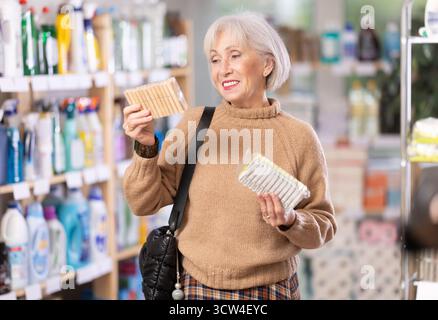 Donna che sceglie un set di clothespins nel negozio Foto Stock