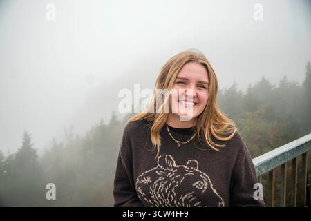 Una donna che indossa un maglione a tema barba è in piedi con sicurezza su un ponte Foto Stock