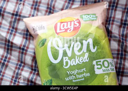 KIEV, UCRAINA - 19 APRILE 2025 giace lo yogurt al forno con patatine aromatizzate all'erba in una confezione verde con il logo ufficiale Foto Stock