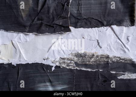Grana per poster strappata. Sfondo Grunge astratto con strati in bianco e nero increspati e increspati. Foto Stock