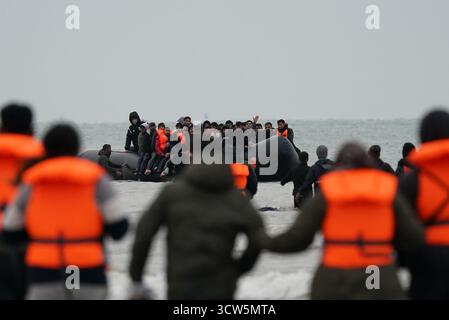 La gente pensata come migranti si tuffò in mare per salire a bordo di una piccola barca a Gravelines, in Francia. Data foto: Venerdì 10 ottobre 2025. Foto Stock