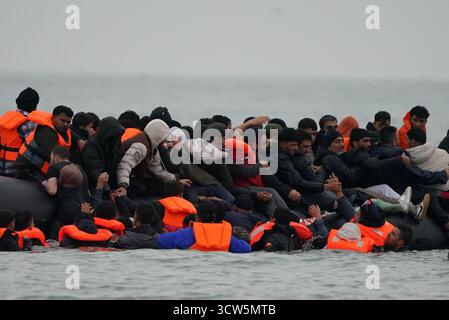 La gente pensata come migranti si tuffò in mare per salire a bordo di una piccola barca a Gravelines, in Francia. Data foto: Venerdì 10 ottobre 2025. Foto Stock