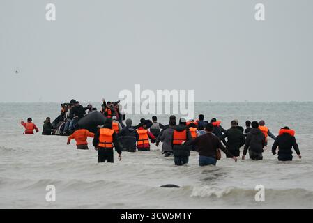 La gente pensata come migranti si tuffò in mare per salire a bordo di una piccola barca a Gravelines, in Francia. Data foto: Venerdì 10 ottobre 2025. Foto Stock