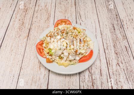 Insalata classica di Cobb con strisce di pollo alla griglia, spicchi di avocado, uova sode tritate, pancetta croccante e formaggio blu sbriciolato sulla lattuga Foto Stock