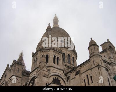 Basilica Sacré-Cœur nella nebbia parigina pesante - dettaglio architettonico ravvicinato di un edificio con la cupola principale e la croce della basilica del Sacro-Cœur disapp Foto Stock