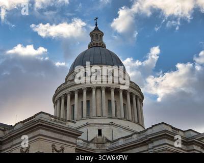 Panthéon Dome contro il suggestivo cielo nuvoloso - primo piano ad angolo basso della maestosa cupola e tamburo a colonna del Panthéon in stile neoclassico, ricoperto da una croce Foto Stock