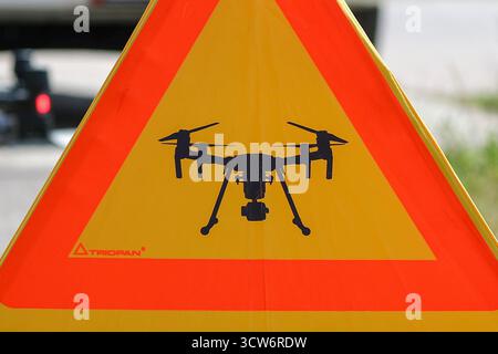 Braunsbedra, Germania. 17 giugno 2025. Un segnale di avvertimento con un simbolo per i droni si trova su una strada di campagna. I droni sono sempre più utilizzati dai vigili del fuoco per supportare le operazioni di ricerca e soccorso. Crediti: Jan Woitas/dpa/Alamy Live News Foto Stock