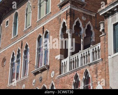 Intricate finestre gotiche veneziane e dettagli del balcone - Vista ravvicinata di una facciata storica del palazzo veneziano caratterizzata da intricate finestre ad arco gotico, Foto Stock