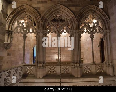 Archi e balaustre del Palazzo neogotico ornamentali - intricata arcata in pietra con trame in quadrifoglio, colonne sottili e una balaustra decorativa interna Foto Stock