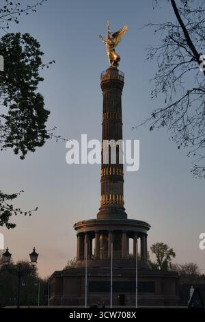 Statua dorata della colonna della Vittoria di Berlino - la statua dorata della Vittoria sulla colonna della Vittoria di Berlino (Siegessäule) che si illumina alla luce della sera, incorniciata Foto Stock