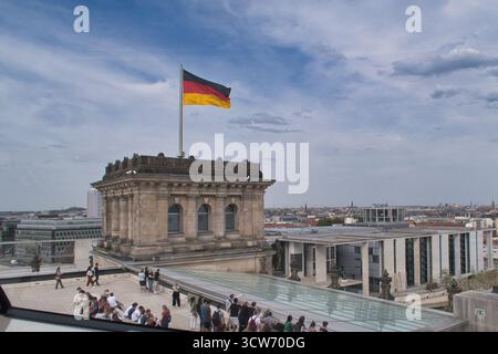 Bandiera tedesca sul tetto del Reichstag, vista di Berlino - Vista panoramica panoramica panoramica dalla terrazza sul tetto del Reichstag, con la bandiera tedesca in cima agli storici buildi Foto Stock