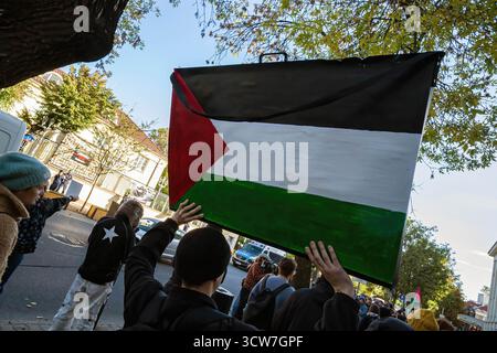 Un manifestante ha un cartello con un'immagine della bandiera palestinese. La mattina del 2 ottobre, i sostenitori filo-palestinesi si sono riuniti presso l'ambasciata israeliana per protestare contro l'intercettazione illegale di Israele e la detenzione dei partecipanti della Flotilla globale Sumud. Con oltre 40 navi, l'ultima flottiglia globale di Sumud per fornire aiuti a Gaza e rompere il blocco navale israeliano era una delle più grandi e partì da Barcellona alla fine di agosto prima di essere intercettata all'inizio di ottobre. Tra i partecipanti vi erano quattro polacchi, Ewa Jasiewicz, Nina Ptak, il deputato polacco Franek Sterczewski e Polis Foto Stock